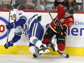 Vancouver Canucks' Wacey Hamilton, left, collides with Calgary Flames' Kris Versteeg during first period NHL pre-season action in Calgary, Alta., Wednesdy, Sept. 20, 2017.