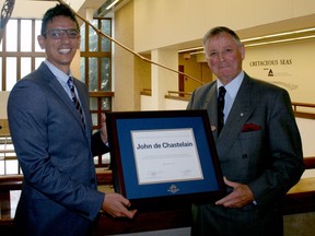 MRU professor Mark Ayyash presents retired Canadian general  John de Chastelain with a plaque recognizing the renaming of the university's peace initiative program after the one-time pupil.'