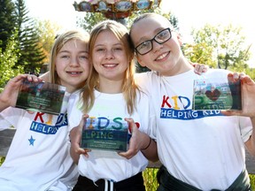 Friends Ainsley Marbach, 11, Peighton Johnson, 12, and Taneil Prouty, 11, hold up their Hero AwardÕs at the Kids Helping Kids celebration at Calaway Park as the three girls teamed up to run a lemonade stand and bake sale in their hometown of Brooks and raised more than $2,200 to support the Alberta ChildrenÕs Hospital Foundation on on Sunday September 17, 2017. Darren Makowichuk/Postmedia