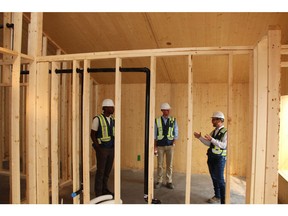 Doug Owens, senior director of operations for Brookfield Residential, right, speaks about passive house construction techniques with Seyi Oyewumi senior business analyst, sustainability and marketing, left, and Brendan McCashin, senior manager, development, centre.