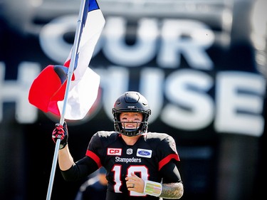 Quarterback Bo Levi Mitchell of the Calgary Stampeders runs onto the field  with the Texas Flag during the player introductions before facing the Edmonton Eskimos in CFL football on Monday, September 4, 2017. Al Charest/Postmedia