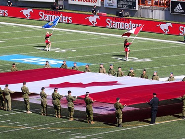 Soldiers carry a huge Canadian Flag during military appreciation day at the Labour Day Classic at McMahon Stadium, Monday September 4, 2017. Gavin Young/Postmedia