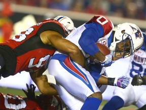 Stamps defender James Vaughters (L) tackles Alouettes running back Stefan Logan during CFL action between the Montreal Alouettes and the Calgary Stampeders in Calgary on Friday, September 29, 2017. Jim Wells/Postmedia