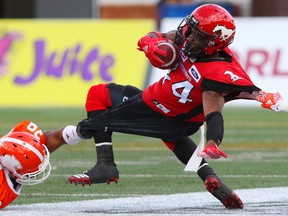 The Calgary Stampeders' Roy Finch is stretched as he runs the ball against the BC Lions during CFL action at McMahon Stadium in Calgary on Saturday September 16, 2017. Gavin Young/Postmedia