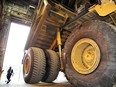 A worker is dwarfed by a Caterpillar 797 heavy hauler at a Syncrude machine shop north of Fort McMurray.