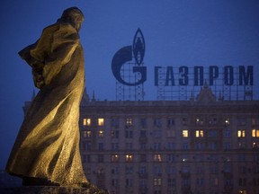 In this March 4, 2014, file photo, a monument to Ukrainian poet and writer Taras Shevchenko is silhouetted against an apartment building with a sign advertising Russia's natural gas giant Gazprom, in Moscow.