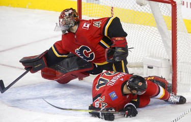 Calgary Flames  Travis Harmonic, right, collides into Flames goalie Mike Smith as a goal is scored by Winnipeg Jets in NHL hockey action at the Scotiabank Saddledome in Calgary on Saturday October 7, 2017. Leah Hennel/Postmedia