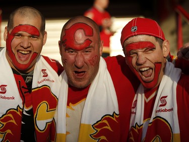 Calgary Flames fans Chris Lee, left Jeremy Kroli and Cody Browne cheer on the flames before they take on the Winnipeg Jets in NHL hockey action at the Scotiabank Saddledome in Calgary on Saturday October 7, 2017. Leah Hennel/Postmedia