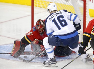 Calgary Flames goalie Mike Smith, left, blocks a shot on net from Winnipeg Jets Shawn Matthias in NHL hockey action at the Scotiabank Saddledome in Calgary on Saturday October 7, 2017. Leah Hennel/Postmedia