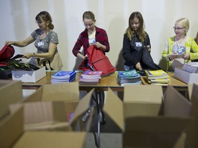 Liz More, left and grade 5 students from Rundle College Elementary School, Olivia, Kenzie and Claire, far right, help pack school bags at Na'amat Canada Calgary during School Supplies for Kids project  in Sunday October 22, 2017. Leah Hennel/Postmedia

POSTMEDIA CALGARY
Leah Hennel, Leah Hennel/Postmedia