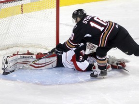 Calgary Hitmen Jakob Stukel, right, scores one of the shoot out goals on Prince George Cougars goalie Taylor Gauthier.