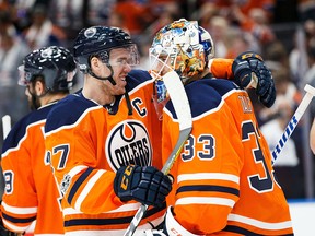 Connor McDavid celebrates the Oilers win with goaltender Cam Talbot, who posted a shutout in the season opener last night.