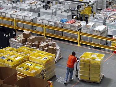 A worker pushes bins at an Amazon fulfillment center in Baltimore.