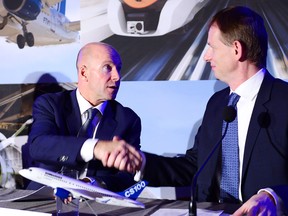Bombardier president and CEO Alain Bellemare, left, and president Canada and chief operating officer of North America for Airbus Helicopters Romain Trapp shake hands during a press conference announcing the CSeries deal in Montreal on Monday.