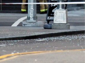 Shards of glass covers the road after falling from an office tower onto 1 street S.W. between 6th and 7th avenues on a windy Sunday morning October 29, 2017.