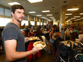 Gareth Lukes, Owner of Lukes Drug Mart helps serve lunch at the Calgary Drop-In and  Rehab Centre.