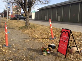 A memorial sign and flowers sits outside Fernie Memorial Arena in Fernie, B.C. on Wednesday, Oct.18, 2017. Three people who died after a suspected ammonia leak were doing maintenance work on ice-making equipment at an arena in southeastern British Columbia, says the city's mayor.
