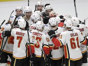 Calgary Flames players celebrate with Matthew Tkachuk (19) after Tkachuk scored the winning goal against the Nashville Predators during a shootout.