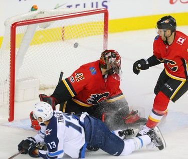 Winnipeg Jets  Brandon Tanev scores on goaltender Mike Smith of the Calgary Flames during NHL hockey at the Scotiabank Saddledome in Calgary on Saturday, October 7, 2017. Al Charest/Postmedia