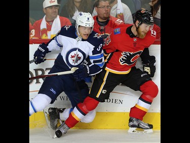 Calgary Flames Sam Bennett gets checked by Andrew Copp of the Winnipeg Jets during the Flames home opener at the Scotiabank Saddledome in Calgary on Saturday, October 7, 2017. Al Charest/Postmedia