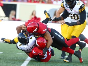 Tiger Cats QB Zach Collaros is sacked by Charleston Hughes and James Vaughters during CFL action between the Hamilton Tiger Cats and the Calgary Stampeders in Calgary at McMahon Stadium Saturday, July 29, 2017.