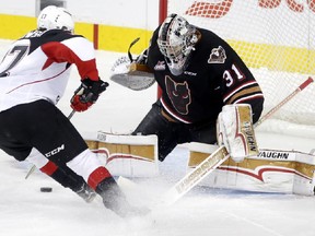 Calgary Hitmen goalie Nick Schneider, right, blocks a shot from Prince George Cougars Dennis Cholowski in WHL action at the Scotiabank Saddledome in Calgary, on Sunday, October 22, 2017. Leah Hennel/Postmedia