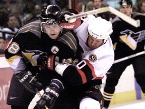 Jaromir Jagr battles through a check by Senators Magnus Arvedson as a Pittsburgh Penguin in 1998.