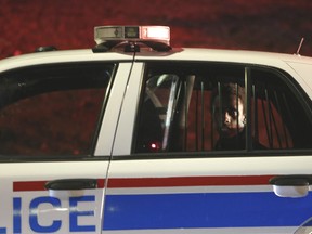 John Garang Luka Yag, 20, sits in the back of a Calgary police car. He faces attempted murder charges in Friday's stabbing of a mother and her six-year-old son. Leah Hennel/Postmedia Network