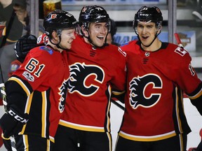 Calgary Flames left wing Micheal Ferland (79) celebrates his goal with defenceman Brett Kulak (61) and centre Mikael Backlund (11) from Sweden, during second period NHL hockey action against the Washington Capitals in Calgary, Sunday, Oct. 29, 2017. THE CANADIAN PRESS/Jeff McIntosh