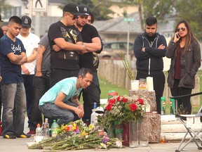 Minh Quach, father of murder victim David Quach, kneels at a memorial to his son in front of the California Boulevard home where he was killed.