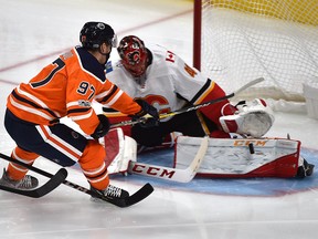 Edmonton Oilers Connor McDavid (97) goes in on Calgary Flames goalie Mike Smith who makes the save during the season opener of NHL action at Rogers Place in Edmonton, October 4, 2017.