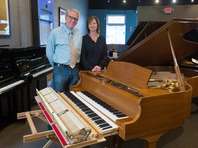 Michael and Nicole Lipnicki, of Michael Lipnicki Fine Pianos, stand next to the keyboard of a 7/8 piano with a regular keyboard next it for scale in the store on Tuesday October 31, 2017. The piano's keyboard was modified for a customer in Calgary and is the first one in the city. Gavin Young/Postmedia