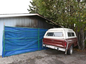 A fence and tarp block off the rear entrance to a garage on Pinemill Rd NE in Calgary Saturday, October 7, 2017. An explosion rocked the garage and house on Friday night, sending three men to hospital. Authorities are investigating the cause.