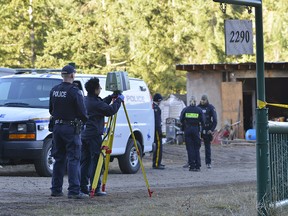 Police are aided by a civilian with laser survey equipment searching a farm near Salmon Arm, B.C., on Monday, October 23, 2017. Police say human remains have been discovered on a rural property on Salmon River Road north of Vernon, B.C. RCMP Cpl. Dan Moskaluk says in a release that officers were executing a search warrant at the property on Saturday when the remains were found. THE CANADIAN PRESS/Desmond Murray ORG XMIT: DEM0006
