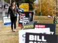 Cassie Sulko walks her dog past numerous election signs on 15th Street and 38th Avenue S.W. in Calgary's Ward 8.