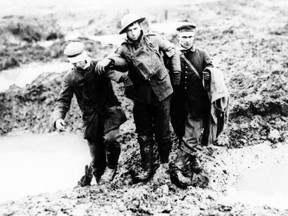 Wounded Canadian and German soldiers help one another through the mud during the Battle of Passchendaele in 1917.