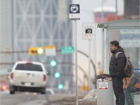 A passenger waits for a downtown bus on Centre Street at 22nd Avenue NW in this file photo from Feb.18, 2015.