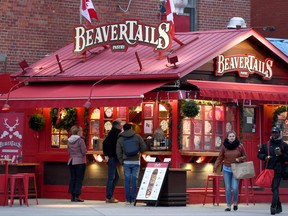 People line up to order outside a BeaverTaila stand in Ottawa's Byward Market on Thursday, Nov. 23, 2017. A trademark flap over a deep-fried Canadian pastry has reached a sweet conclusion. THE CANADIAN PRESS/Justin Tang