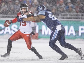 Bo Levi Mitchell #19 of the Calgary Stampeders is sacked by Clayton Laing #90 of the Toronto Argonauts during first quarter action in the 105th Grey Cup Championship Game at TD Place Stadium on November 26, 2017 in Ottawa, Canada.