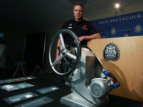 Calgary Police Service Staff Sgt. Mark Hatchette stands behind a pill press that was one of two recovered in a fentanyl and counterfeit currency manufacturing lab in Evanston in September. Gavin Young/Postmedia