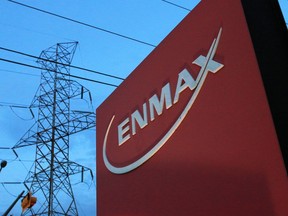 Power lines rise behind an Enmax sign at the company's head office in Calgary.