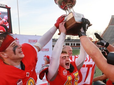 U of C Dinos kicker Niko Difonte raises the Hardy Cup after his 59 yard field goal in the final seconds cinched the game over the UBC Thunderbirds 44-43.