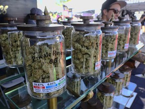 Jars of marijuana are on display for sale at the Cali Gold Genetics booth during the High Times Cannabis Cup in San Bernardino, Calif. California begins recreational marijuana sales on Jan. 1, 2018.