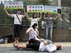 In this July 31, 2014, file photo, gay rights campaigners act out electric shock treatment to protest conversion therapy.
