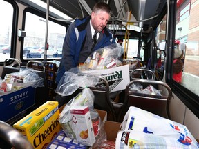 Steve Patrick, Calgary Transit's manager of Infrastructure piles up the donated food during the 25 th annual Stuff a Bus campaing to benefit the Calgary Food Bank Calgary Saturday, November 4, 2017. Patrick lent a helping hand at the Shawnessy Co-op, but Calgarians donated at stores across the city. Jim Wells/Postmedia