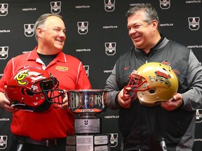 University of Calgary coach Wayne Harris (left) and Université Laval coach Glen Constantin shake hands during the press conference leading up the Mitchell Bowl in Calgary on Friday, November 17, 2017.