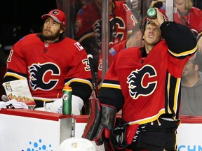 Calgary Flames goaltenders Eddie Lack and Mike Smith (R) during a break in play while facing the Pittsburgh Penguins in NHL hockey at the Scotiabank Saddledome in Calgary on Thursday, November 2, 2017.
