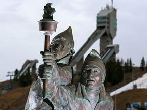 The Olympic torch bearer statue with the Olympic ski jumps in the background at Canada Olympic Park.