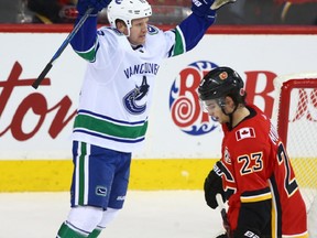 Canucks Derek Dorsett celebrates a second period goal in front of Flames Sean Monahan during NHL action between the Calgary Flames and Vancouver Canucks in Calgary on Tuesday, November 7, 2017. Jim Wells/Postmedia