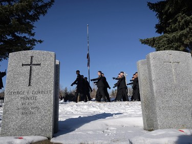 Members of 33 Engineer Squadron, 41 Combat Engineer Regiment, march past grave markers during a Remembrance Day service in Calgary, Saturday, Nov. 11, 2017.